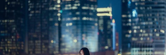 Person using a tablet at night while outside in a large city