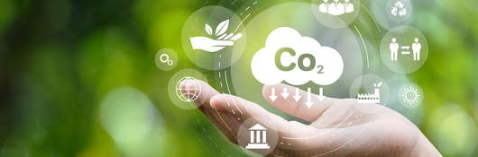 CO2 emission reduction concept in hand with environmental icons, global warming, sustainable development, connectivity and renewable energy green business background.