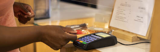 A person making a contactless credit card payment