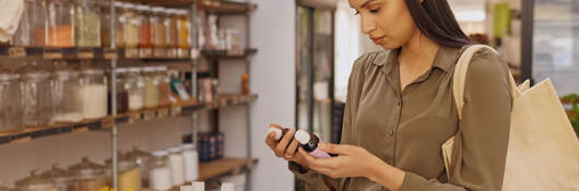 Person reading a label on a product while shopping in a store