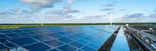 The solar photovoltaic power station on the water surface and the wind turbine in the distance.