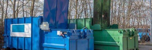 Two large garbage compactors.