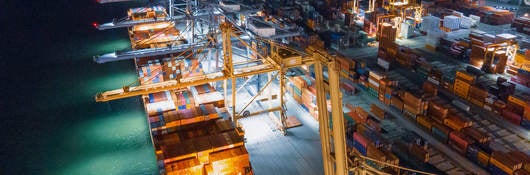 A cargo ship docked with many shipping containers