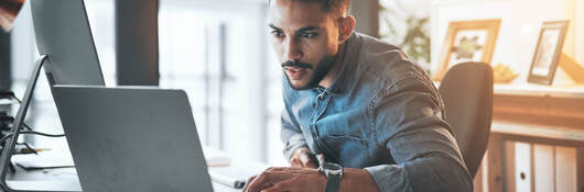 Person reviewing information on a laptop in a loft office