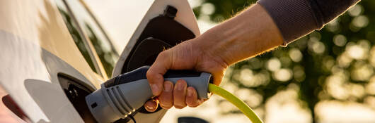 A person charging an electric vehicle