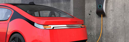 A red electric vehicle is charging at a wall charger