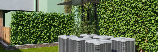 Six outdoor air conditioning units in the backyard