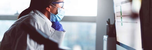 A chemist reviewing data on a laptop