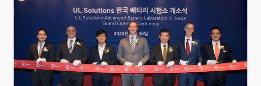 Seven people cutting a ribbon at the UL Solutions Korea laboratory ribbon cutting ceremony