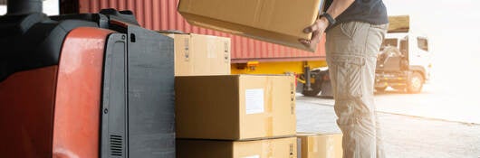 A warehouse worker loading boxes onto a pallet