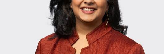 Headshot of Sreelatha Surendranathan in red jacket. 