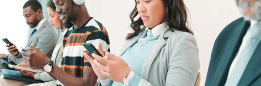 People in a waiting room and using mobile devices