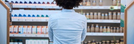 a person looking at a shelves of many health products