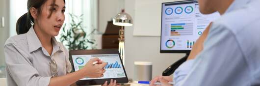 Two business professional discussing metrics during a meeting