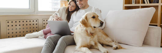 A couple and their dog on the sofa