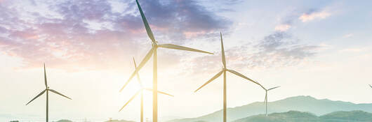 windmills on a hill in an opalescent sunrise