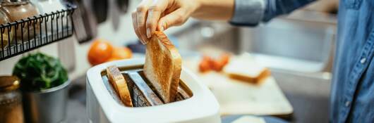 Person making toast in their kitchen