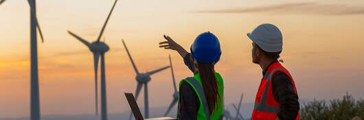 people working on wind farm at sunset