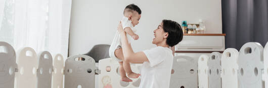 A parent and child playing in a bright nursery