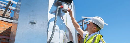 Engineer with clipboard checking the installation of the ventilation system