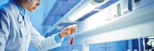 A scientist examining a liquid in a test tube