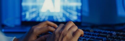 A person typing on a keyboard and using AI