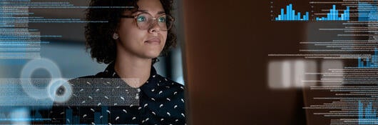 A person reviewing charts on a large monitor