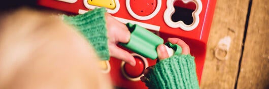 A child playing with a shape board
