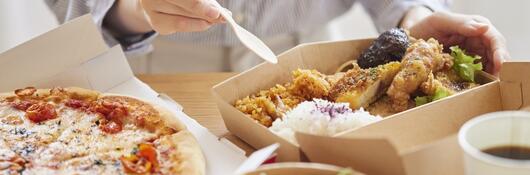 A person placing food into cardboard containers
