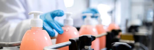 A person handling detergent bottles in a laboratory