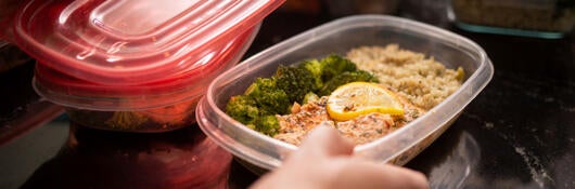 A person using plastic food storage containers