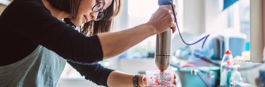A person using a hand mixer