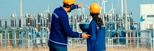 Two people working near an electrical grid