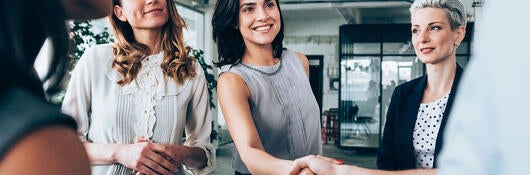 A group of people, two are shaking hands
