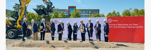 Group of people in suits and hard hats with shovels for groundbreaking