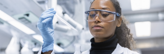 black female scientist with chemical in flask
