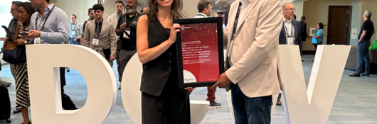 Chante Maurio, VP of Data Centers, presents Manav Patel, VP of Strategy and Transformation with a red framed certificate at Data Center World Power on Sept. 22, 2026