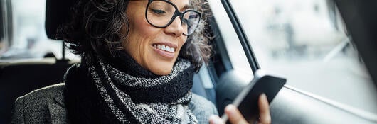 woman in car looking at phone