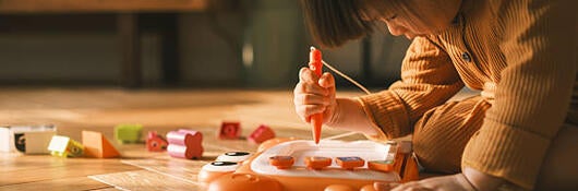 Toddler drawing on a magnetic drawing board on the floor 
