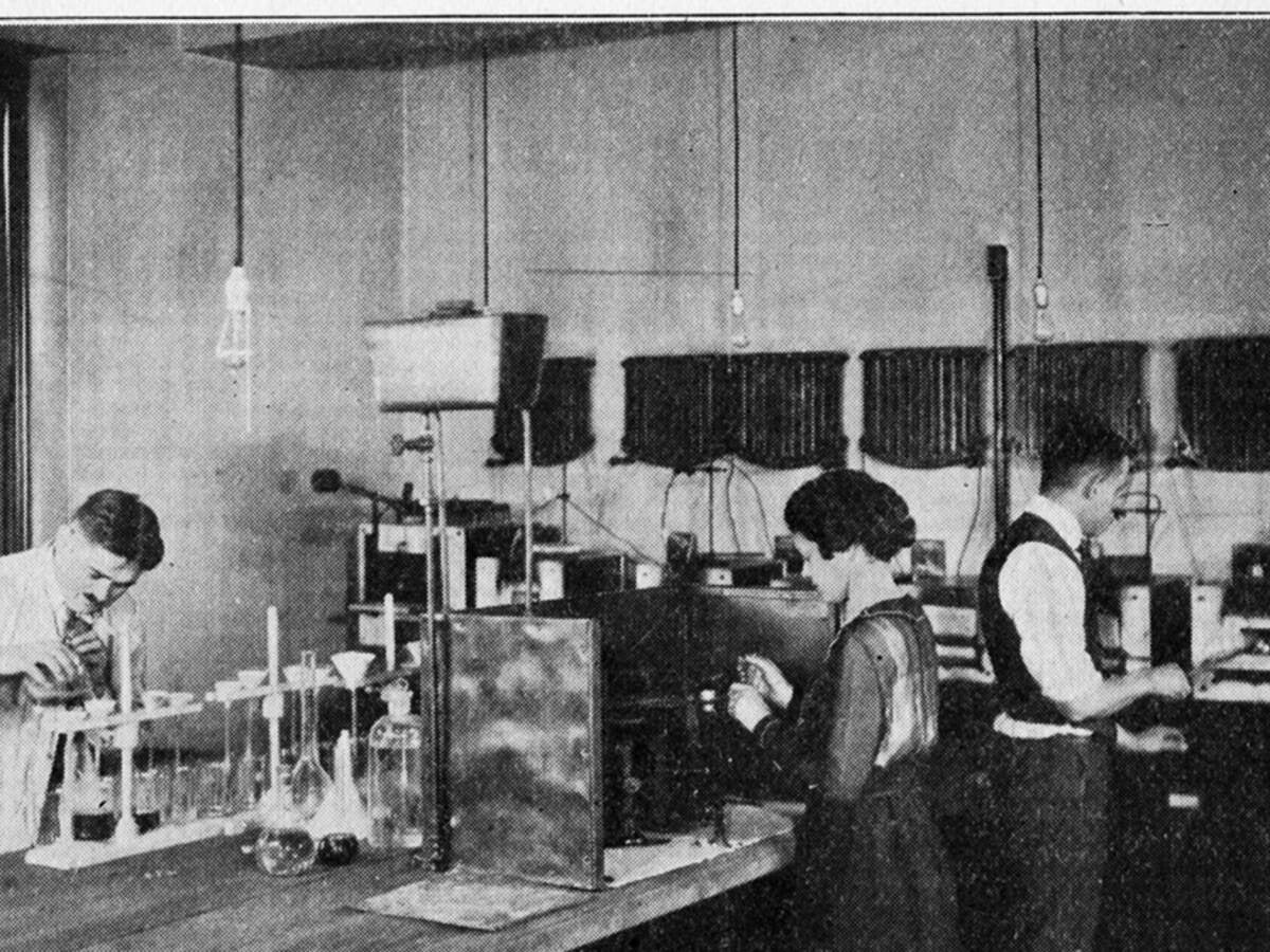 UL chemists workiing on a counter circa 1920s, Group of chemists standing around a long table, conducting experiments, December 1920, , , , , , , , , , , 