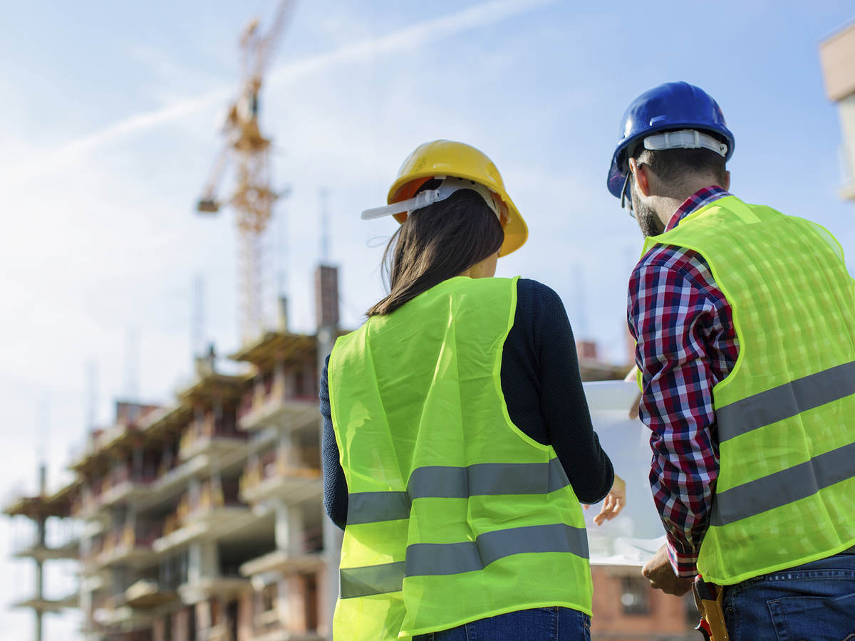 Two architects look at building.