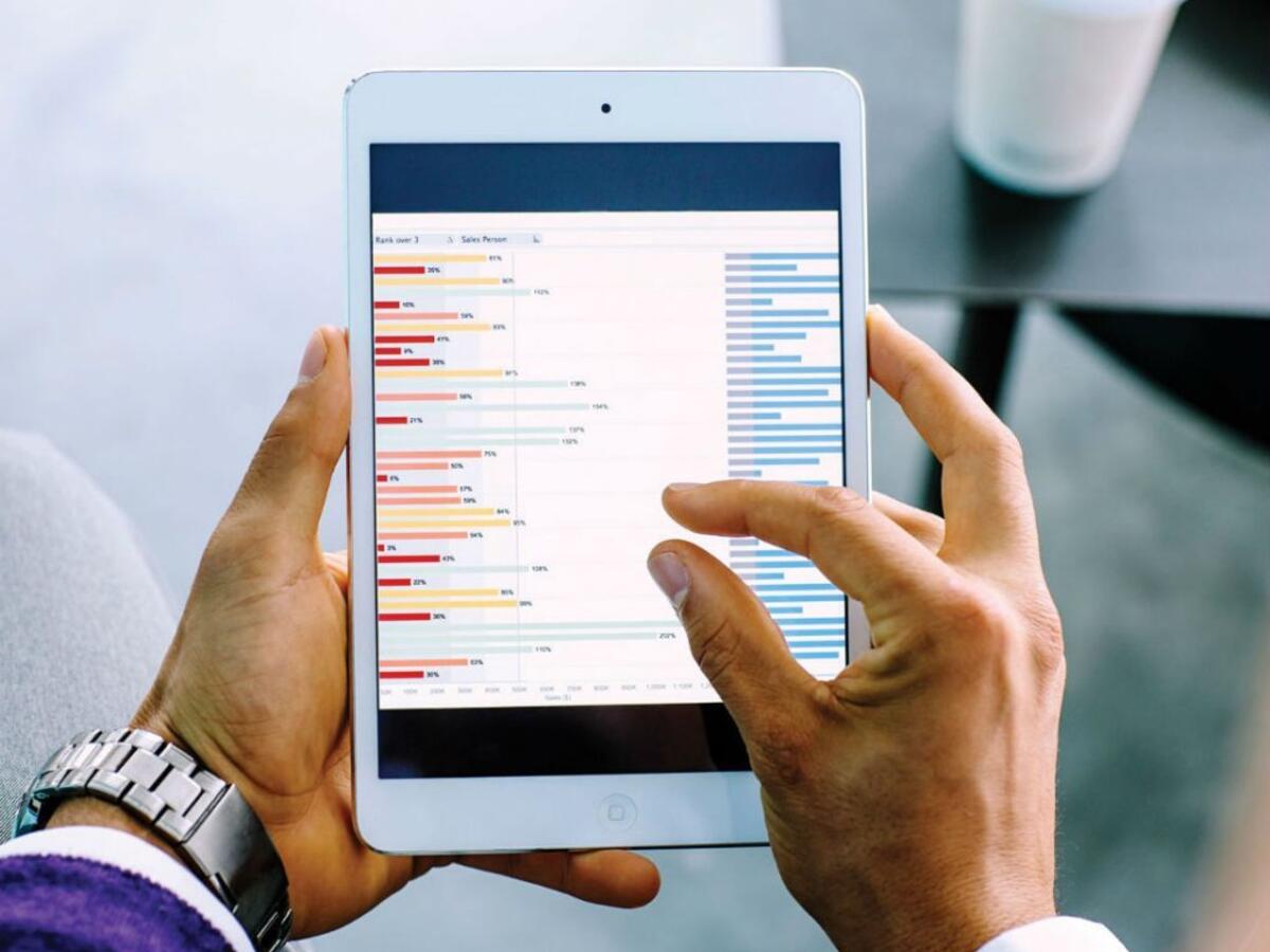 Man reading graphs on a tablet