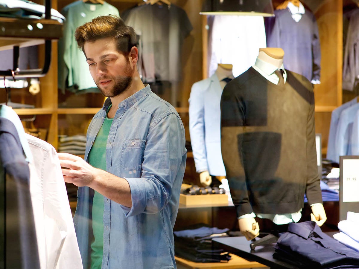 A man browses different articles of clothing.