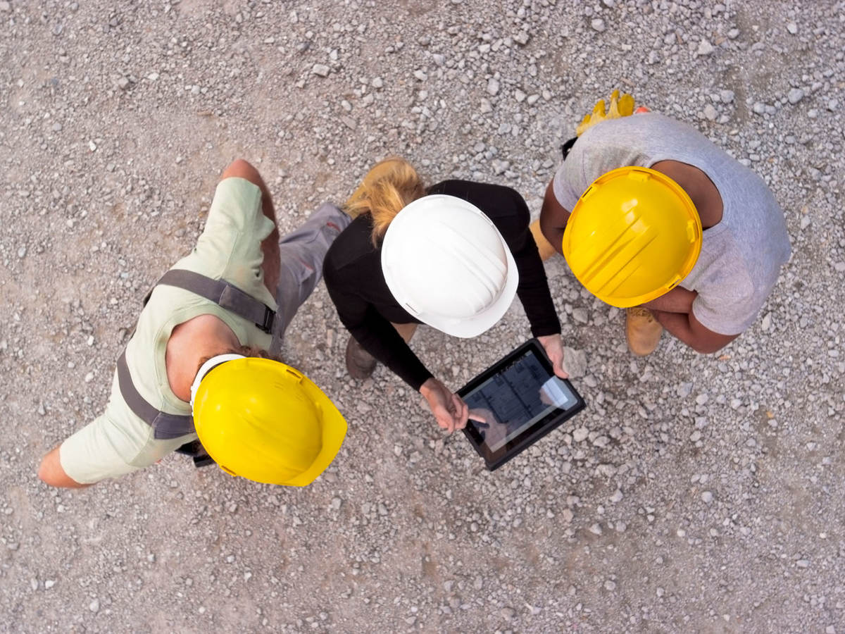 Workers on-site collaborating on a tablet