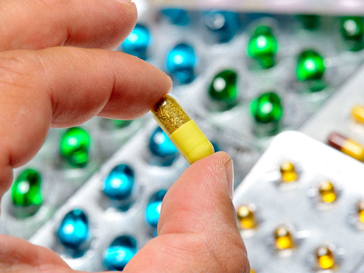 Close-up of hand holding a pill