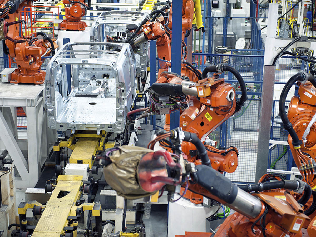 Vehicle factory manufacturing with robotic arms and automation.