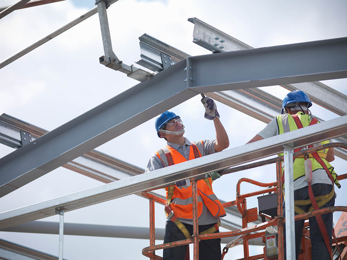 A construction worker laboring on a steel structure