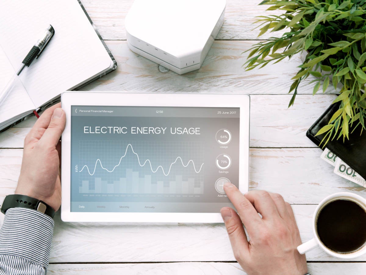 Man holds tablet PC with electric energy usage application