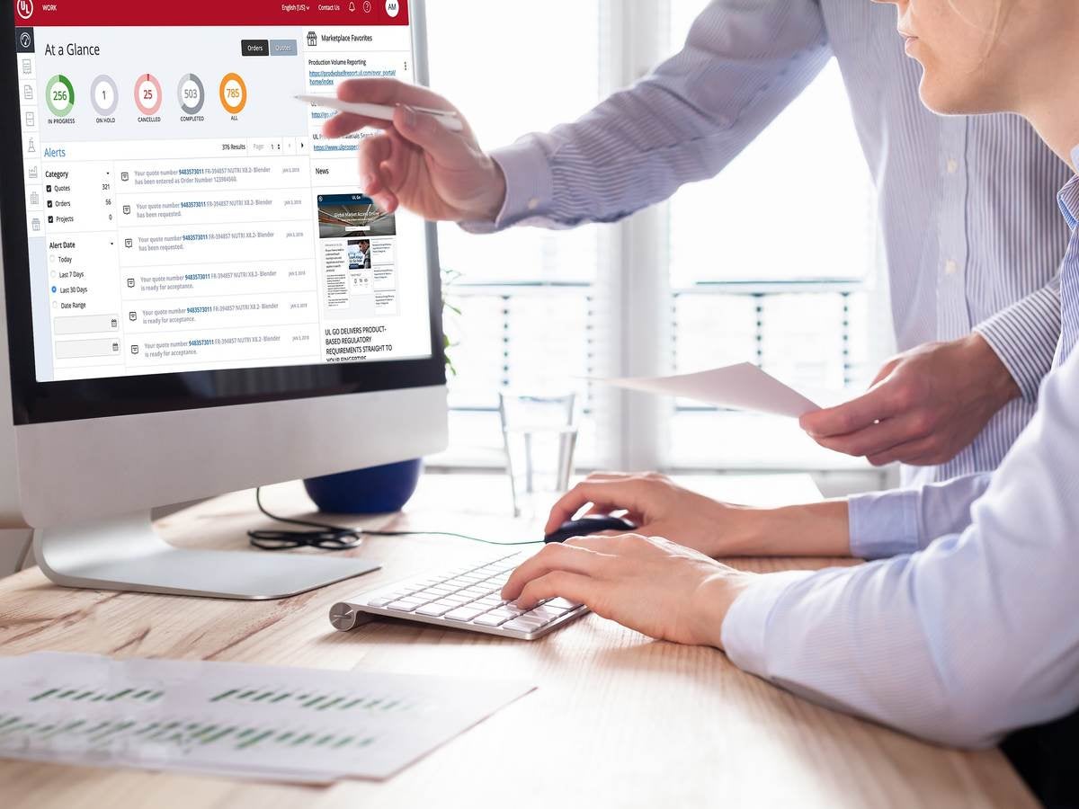 An office worker is being shown the new myUL portal on the computer.