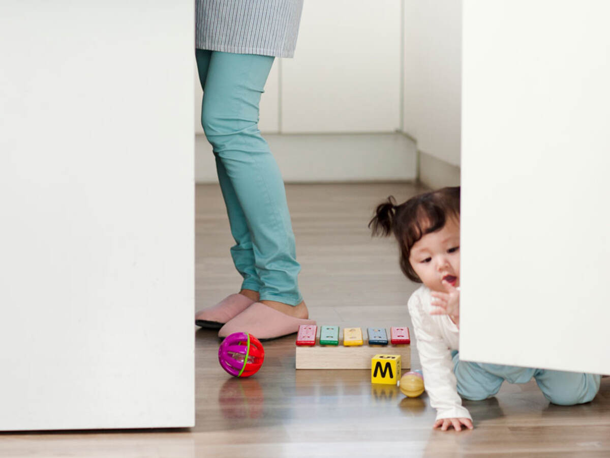 Child playing with toys on the kitchen floor.  